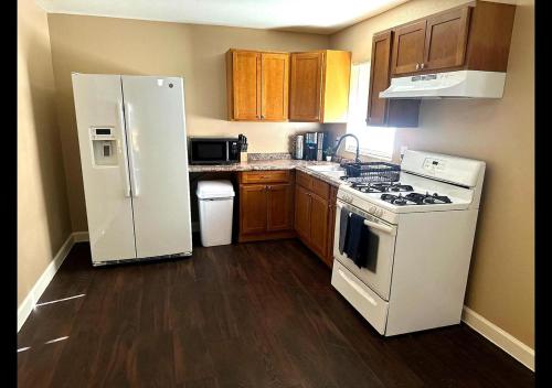 a kitchen with a white refrigerator and wooden cabinets at Miami Court Single Cottage #1 in Lakeland