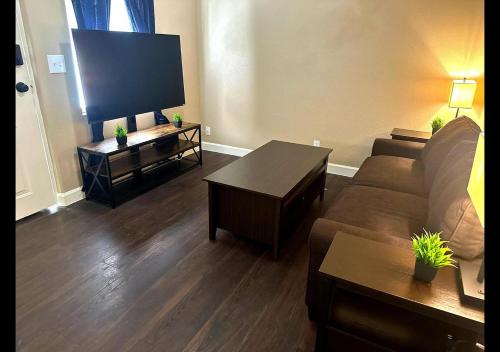 a living room with a couch and a flat screen tv at Miami Court Single Cottage #1 in Lakeland