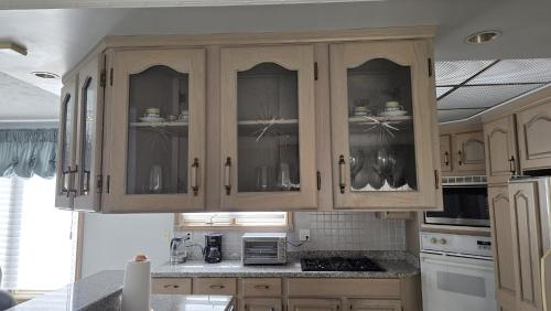 a kitchen with wooden cabinets and a counter top at Spacious, Peaceful & Perfectly Located - 4BR,3BA in London