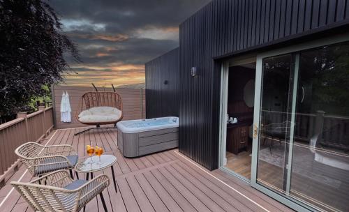 a deck with a hot tub and a table and chairs at Bellinter House Hotel & Spa in Navan