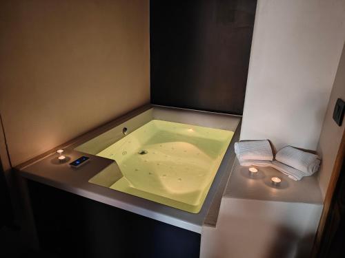 a small bathroom with a green bath tub with lights at Le Grenier d'Antan - Relax Suite in Aosta