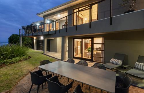 a house with a table and chairs on a patio at Papillon in Stilbaai