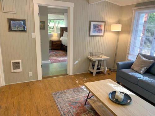 a living room with a couch and a table at Cozy cottage among trees - close to PDX in Vancouver
