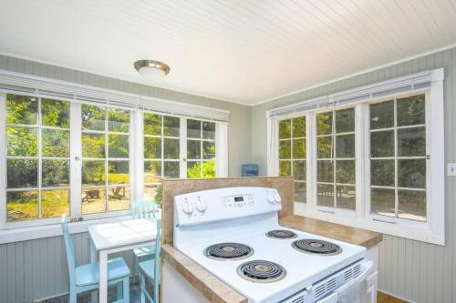 a kitchen with a stove and some windows at Cozy cottage among trees - close to PDX in Vancouver