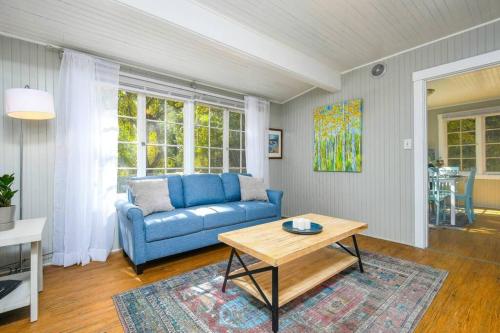 a living room with a blue couch and a table at Cozy cottage among trees - close to PDX in Vancouver