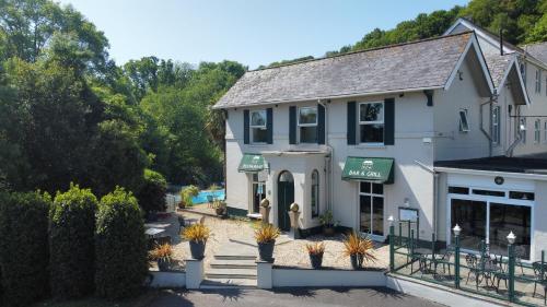 a white building with a green awning on it at Fernhill Hotel in Lyme Regis