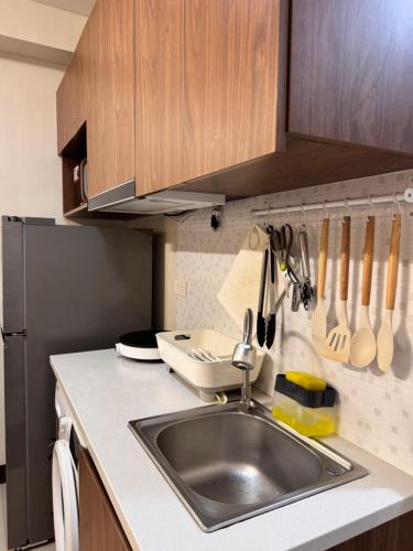 a kitchen with a sink and a refrigerator at Condo in Lapu-Lapu City in Suba