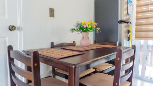 een eettafel met een vaas met bloemen erop bij The terrazzo house in Santa Ana