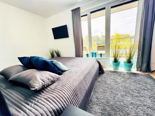 a bedroom with a bed with pillows and a window at Baltic Spot Apartment Letnica in Gdańsk