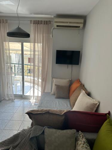 a living room with a couch and a tv at Lara3 in Kavala