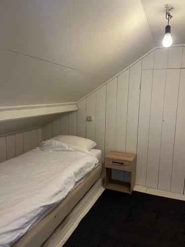 a bedroom with a white bed and a night stand at Apartment with wide views in Pingjum