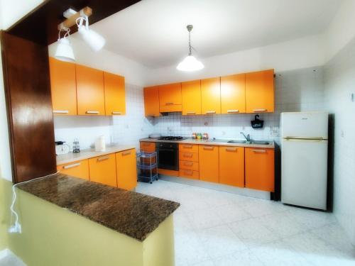 a kitchen with orange cabinets and a white refrigerator at Eremo Cilento Experience in Agnone