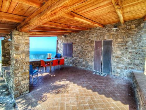a living room with a table and a stone wall at Eremo Cilento Experience in Agnone