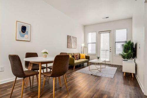 a living room with a table and chairs and a couch at Boulevard Stays Walk to Downtown 1BR SoCo Pool Parking Gym 01 in Austin