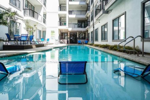 a swimming pool with blue chairs in a building at Boulevard Stays Walk to Downtown 1BR SoCo Pool Parking Gym 01 in Austin