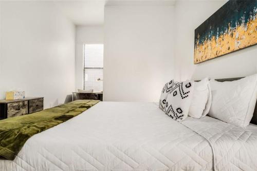 a white bedroom with a large bed with white pillows at Boulevard Stays Walk to Downtown 1BR SoCo Pool Parking Gym 01 in Austin
