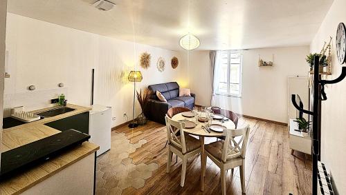 a kitchen and a living room with a table and a couch at Maison de ville calme au cœur de Chartres Netflix, salle de sport, garage vélo in Chartres