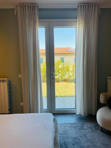 a bedroom with a bed and a sliding glass door at Blueyes House Tuscany in Montespertoli