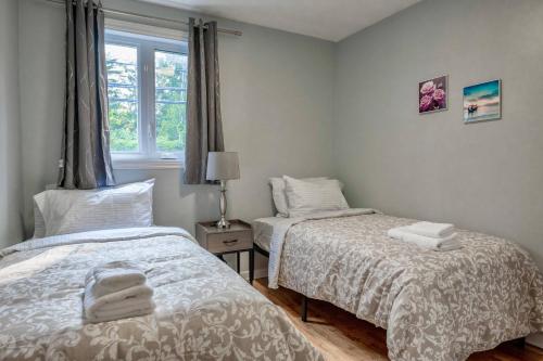 a bedroom with two beds and a window at 3BR 6Beds 5min Walk Metro Free Parking Place Bell in Laval