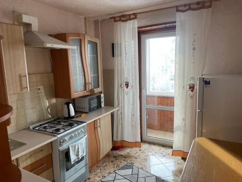 a small kitchen with a stove and a window at Ліор in Lviv
