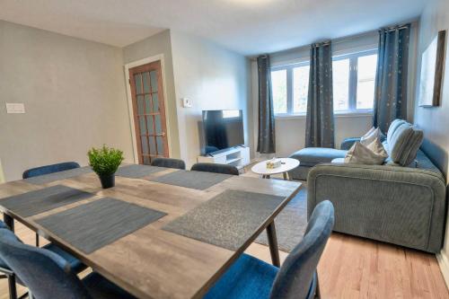 a living room with a wooden table and chairs at 3BR 6Beds 5min Walk Metro Free Parking Place Bell in Laval