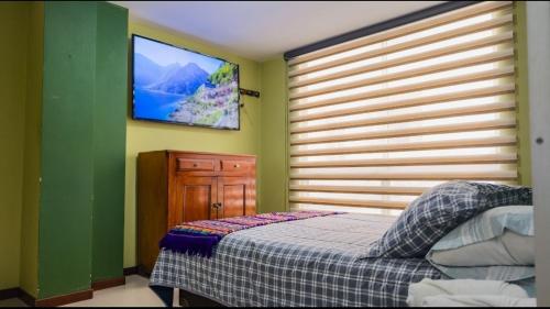 Un dormitorio con una cama y un televisor de pantalla plana. en Comfort and privacy in an exclusive area of Pasto, en Pasto