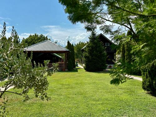 a yard with a gazebo and a house at Wooden House - Imanje Terzic in Podgorica
