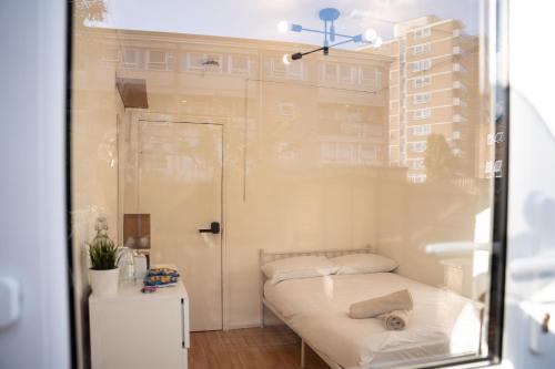 a small room with a bed and a window at Private Rooms near Canary Wharf in London