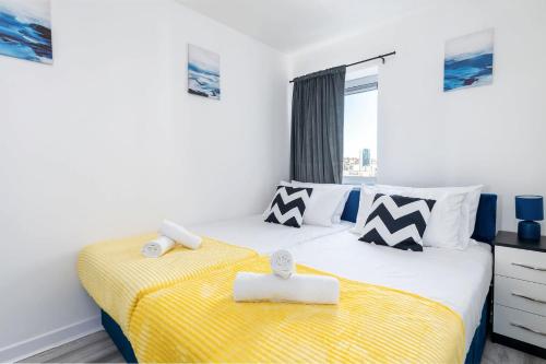 a bedroom with two beds with yellow and white sheets at 2 Bedroom 2 Bathroom Apartment with 5 Beds and Gated Parking near Sheffield United Stadium in Sheffield
