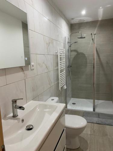 a bathroom with a sink and a toilet and a shower at L'orangerie in Seignosse