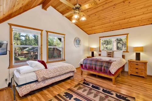 a bedroom with two beds and a wooden ceiling at Cub's Cabin #2561 in Big Bear Lake