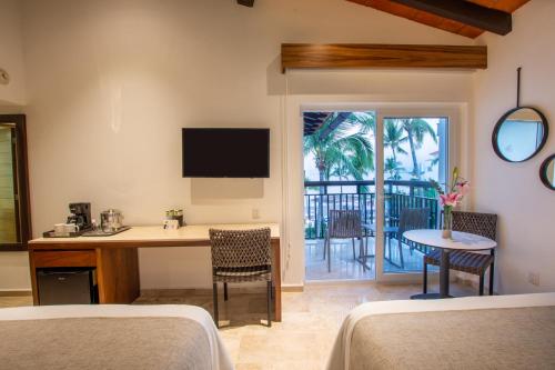 a room with two beds and a table with a desk at Buenaventura Grand Hotel & Great Moments - All Inclusive in Puerto Vallarta
