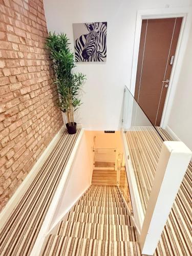 a staircase in a house with a brick wall at Chiswick Guest Rooms in London