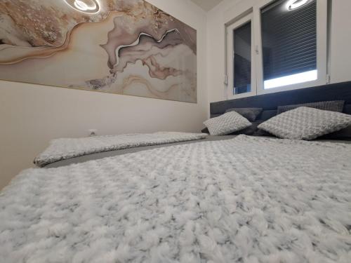 a large bed in a bedroom with a painting on the wall at Apartman So Chic kod Kastela in Banja Luka