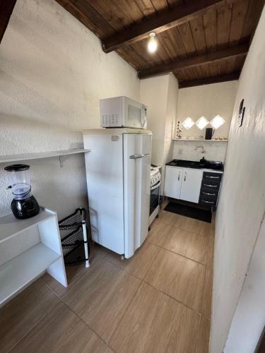 a kitchen with a white refrigerator and a stove at Pousada Albino Goedert in Passo De Torres