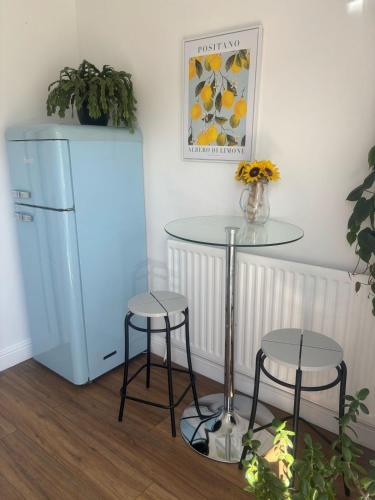 a table and stools in a room with a refrigerator at The Ivy Nook in Hartlepool