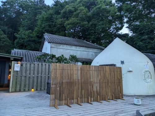 a wooden fence in front of a house with a building at 貸切古民家別邸 in Tsukuba