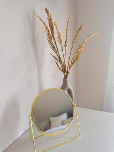 a mirror sitting on a table next to a vase at Ferienhaus zum See Sonnenglanz in Funfseen