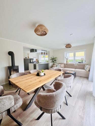 a living room with a wooden table and chairs at Ferienhaus zum See Sonnenglanz in Funfseen