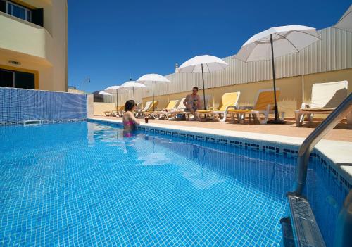 a little girl is standing in a swimming pool at Torre da Aldeia by Umbral in Albufeira