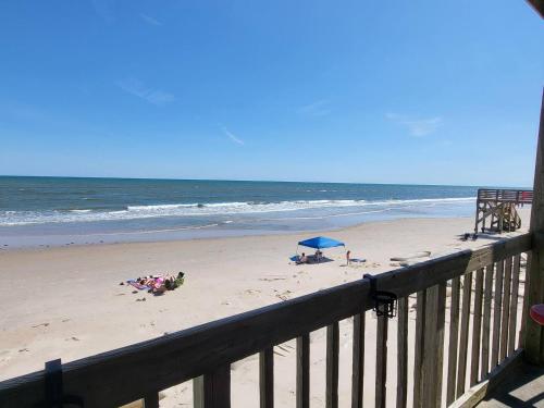a beach with people on the sand and the ocean at Steps To The Ocean! 285 in North Topsail Beach