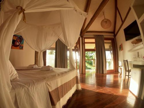 a bedroom with a bed with a canopy at T Tree Luxury Villa in Pipa