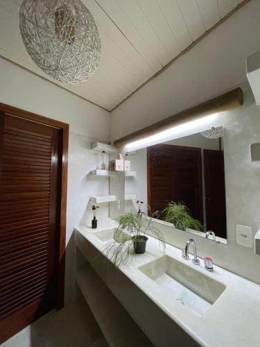 a bathroom with a sink and a large mirror at T Tree Luxury Villa in Pipa
