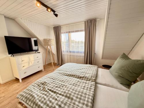 a bedroom with a couch and a tv and a window at Ferienwohnung Stage One Zentrale Lage in Weißenthurm