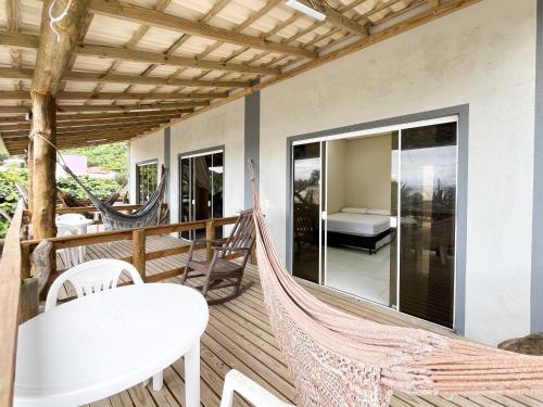 a hammock on the deck of a house at Loft Sol e Mar Exclusivo em Bombinhas 50m da praia in Bombinhas