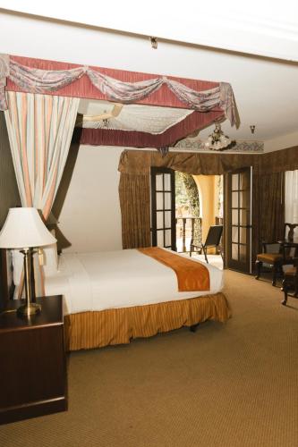a bedroom with a large bed with a canopy at Historic Santa Maria Inn in Santa Maria