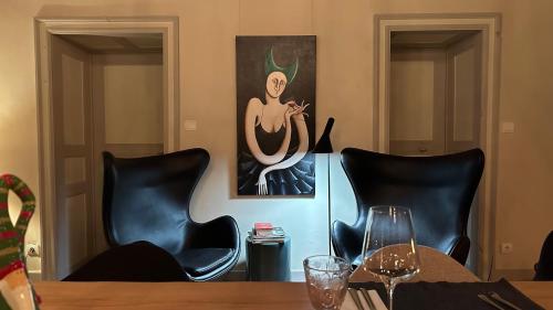 a table with black chairs and a painting on the wall at ZONE BLEUE in Hyds