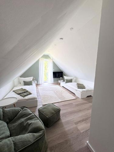 a attic room with two beds and a couch at Ferienhaus zum See Sonnenglanz in Funfseen