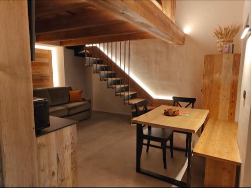 a living room with a table and a staircase at Le Grenier d'Antan - Relax Suite in Aosta