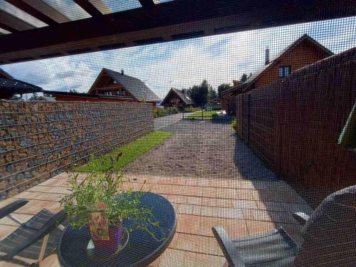 a fence with a potted plant on a patio at Apartman Marienka in Liptovský Trnovec